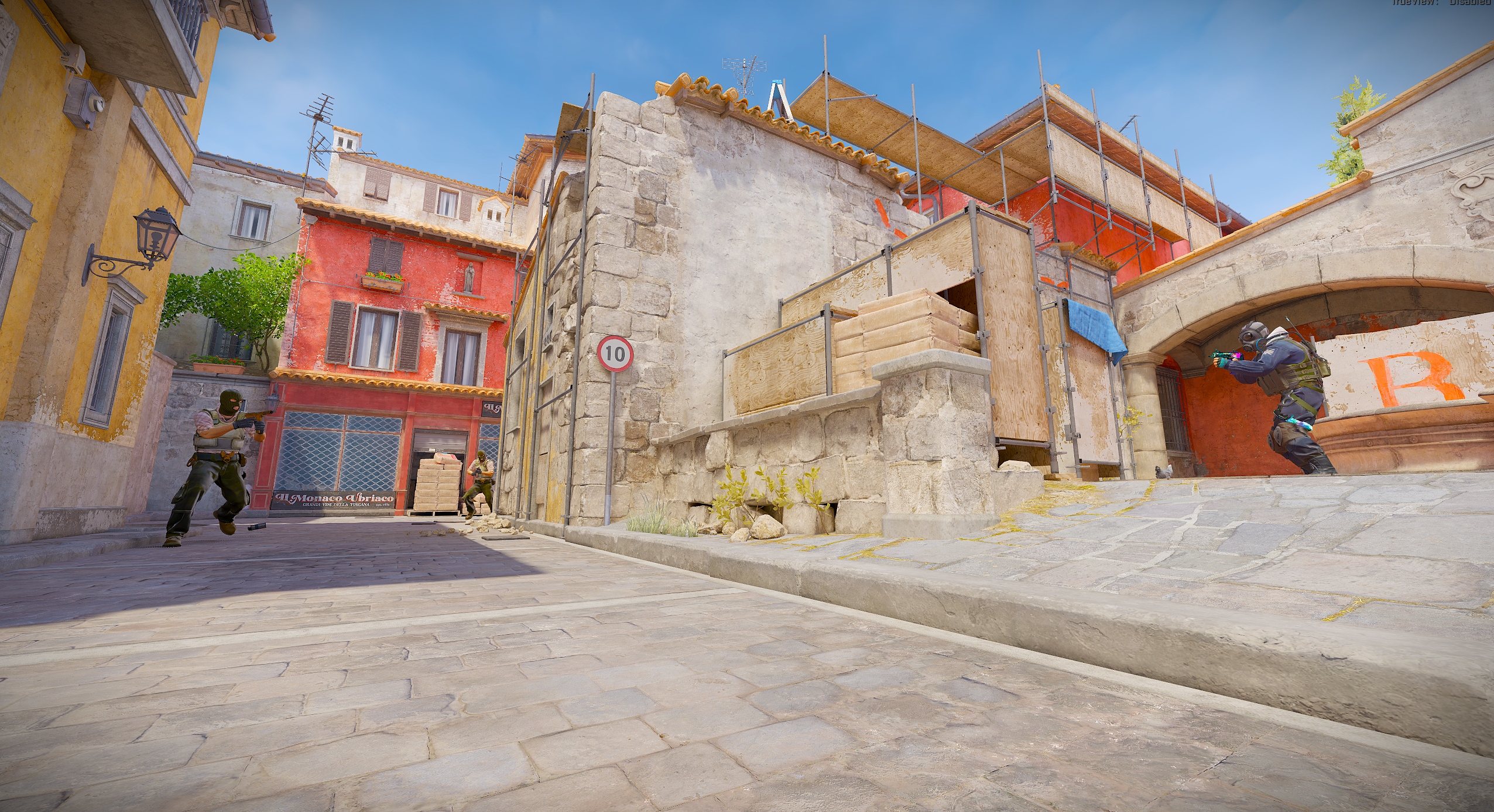 Players facing off beside the stone arches and buildings on Inferno in Counter-Strike 2
